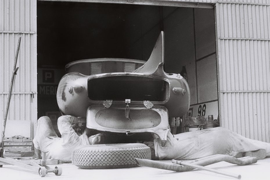 Mechaniker schrauben an einem Jaguar D Type im Fahrerlager (Archiv Völker-Richarz)